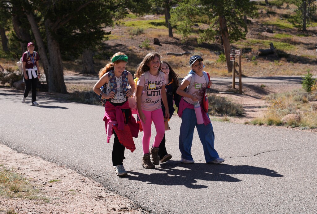 Four girls walking a road side by side