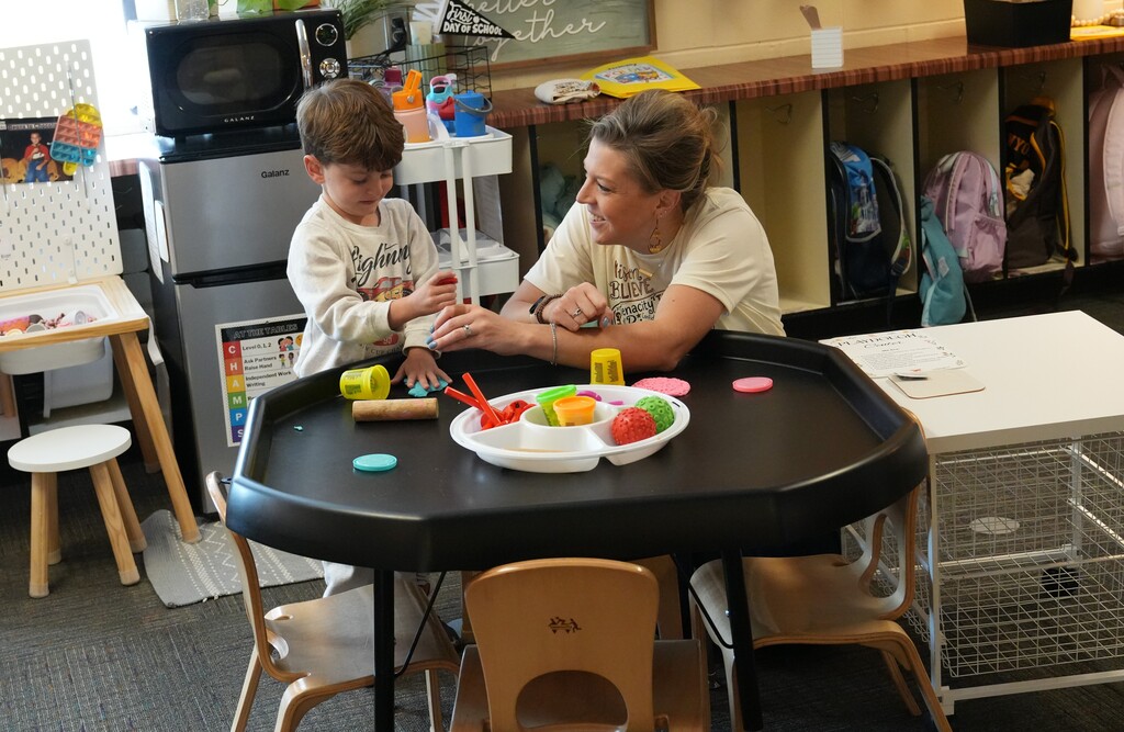 Boy and teacher playing with playdough