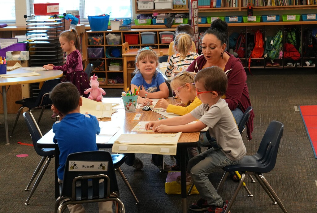 Group of students sitting at a table with their teacher