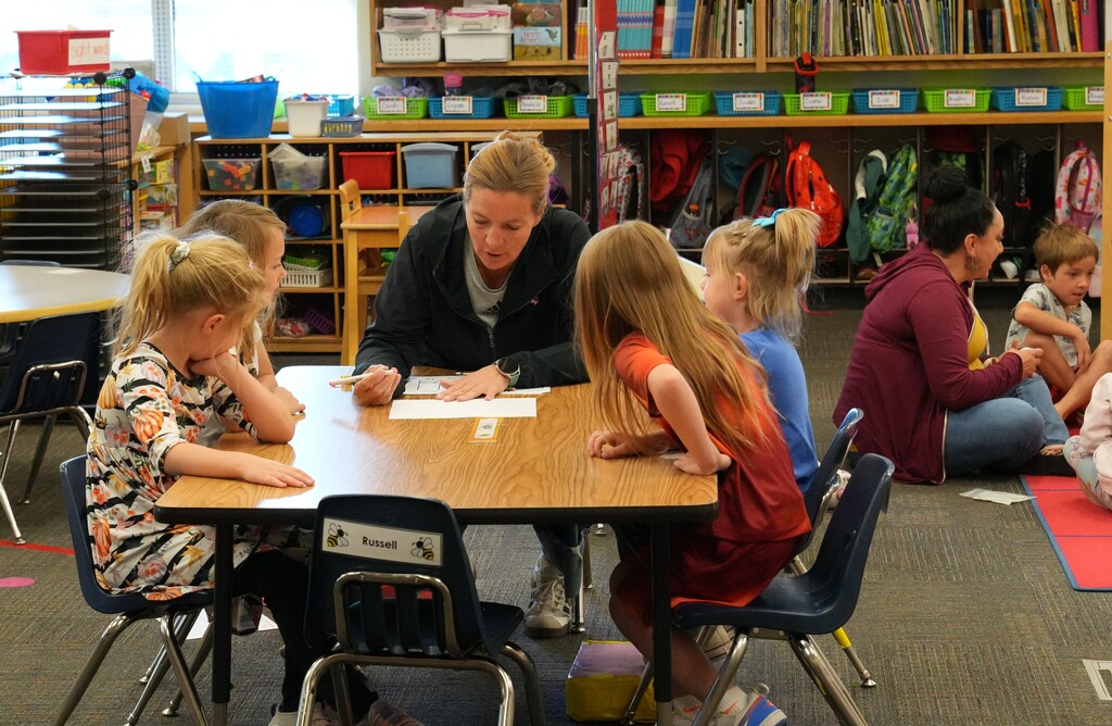 Students sitting around a table with their teacher