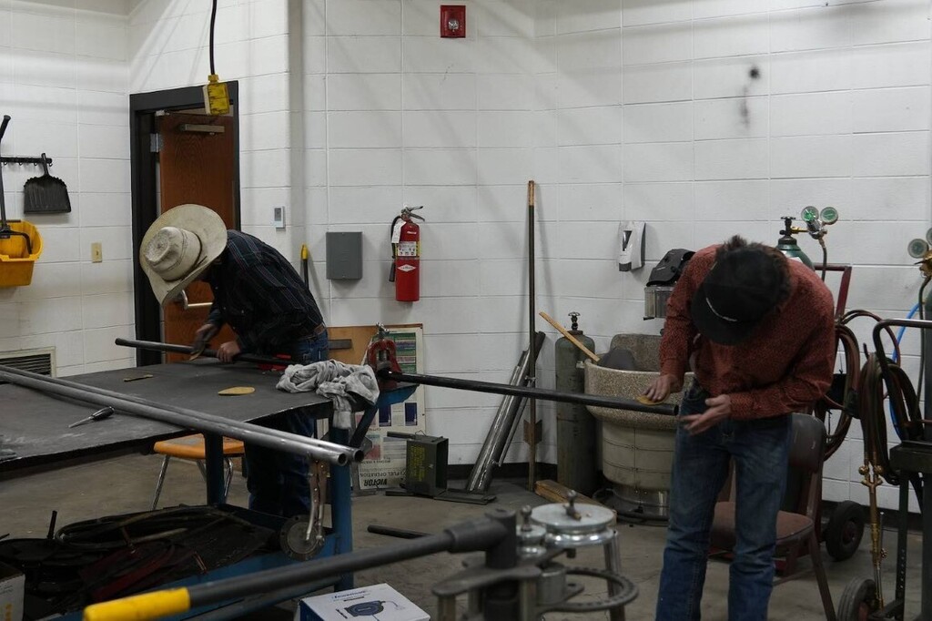 Two boys working with metal at a table