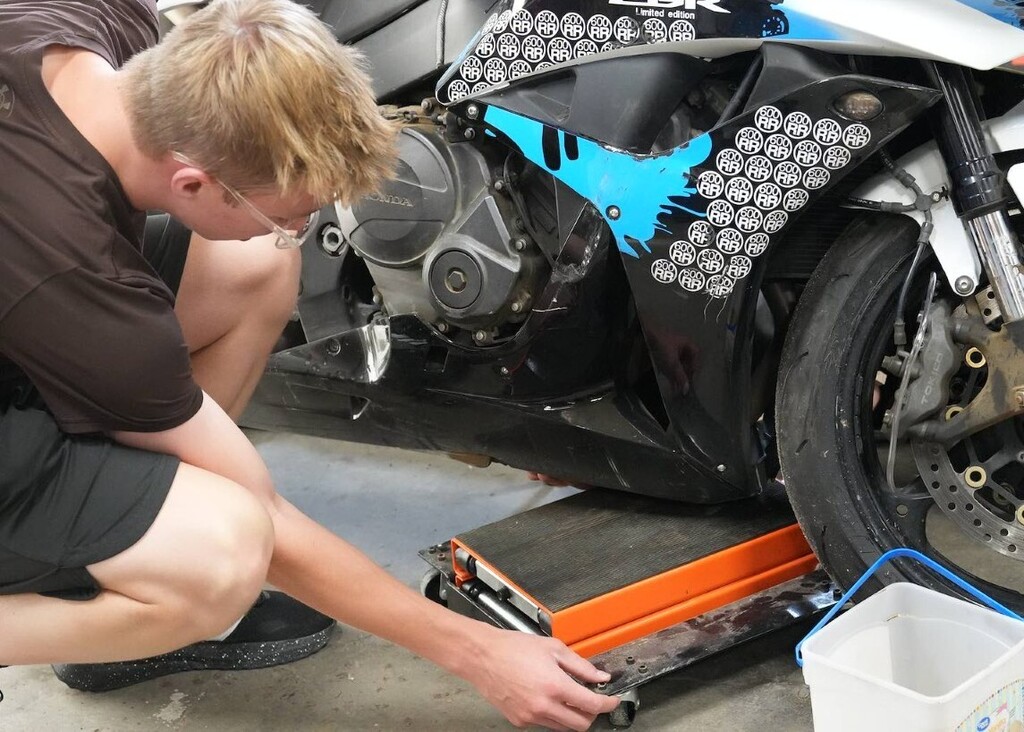 student placing equipment under a bike