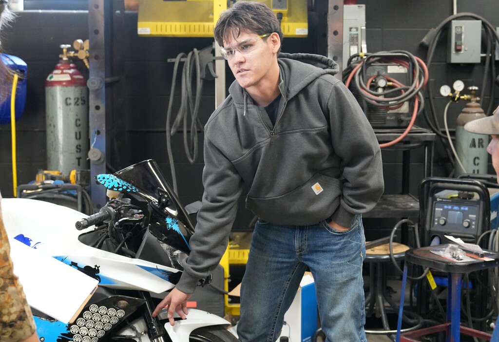 Male student pointing at a dirtbike
