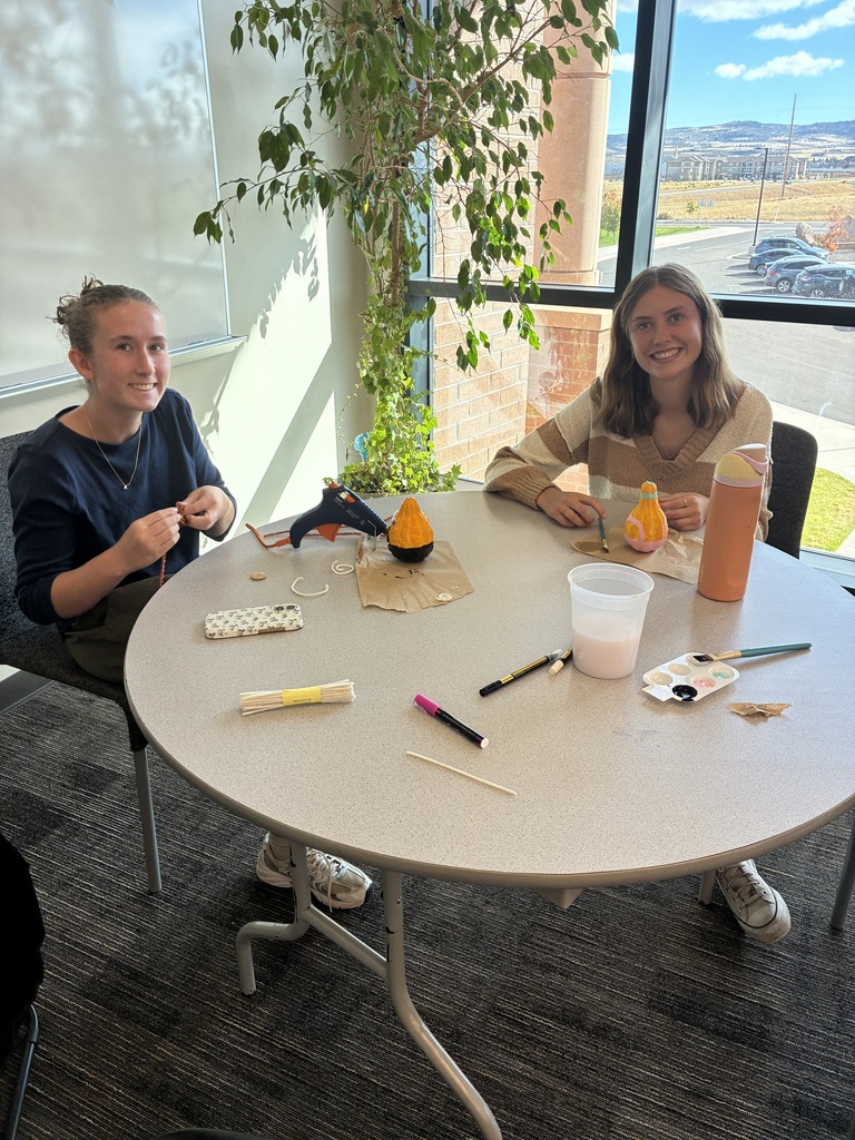 two students painting fall decor