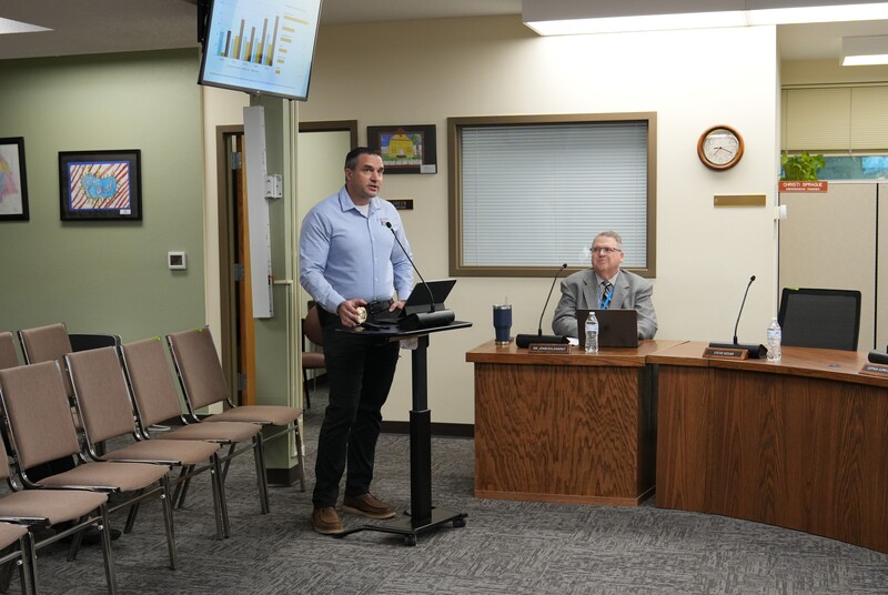 Man in blue shirt standing at a podium presenting