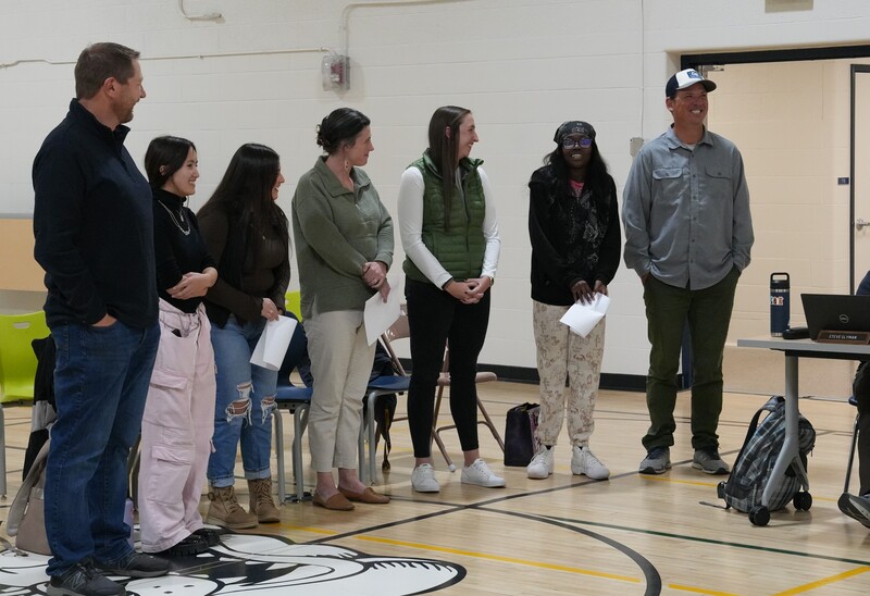 Group of teachers and students talking in a gym
