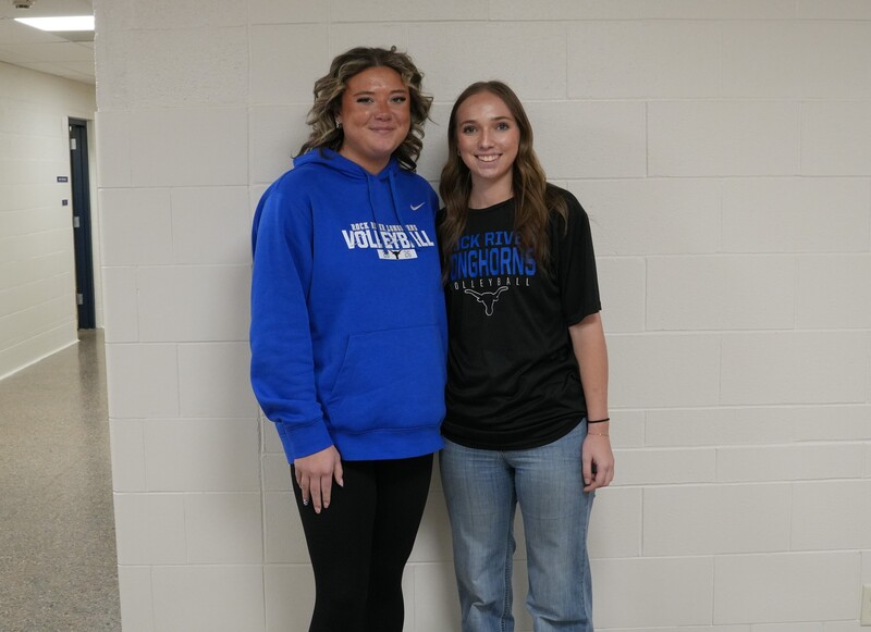 Two girls with brown hair in a blue hoodie and black t-shirt