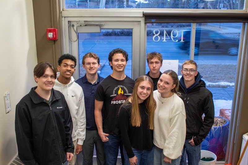 Group of  high school students standing in a doorway smiling