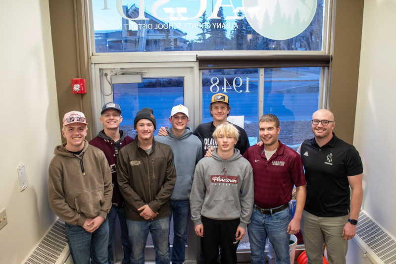 middle school students posing in doorway with teacher