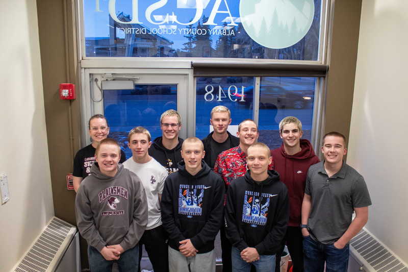 middle school students posing in doorway with teacher