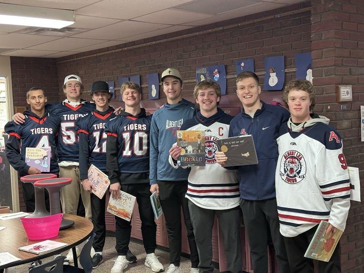 High school athletes reading to elementary students. 