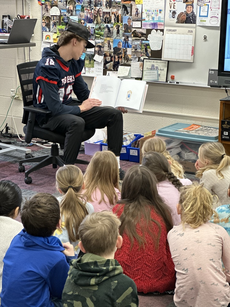 High school athletes reading to elementary students. 