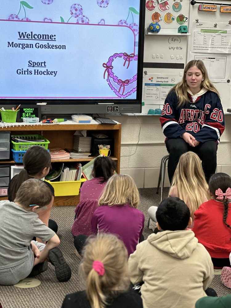 High school athletes reading to elementary students. 