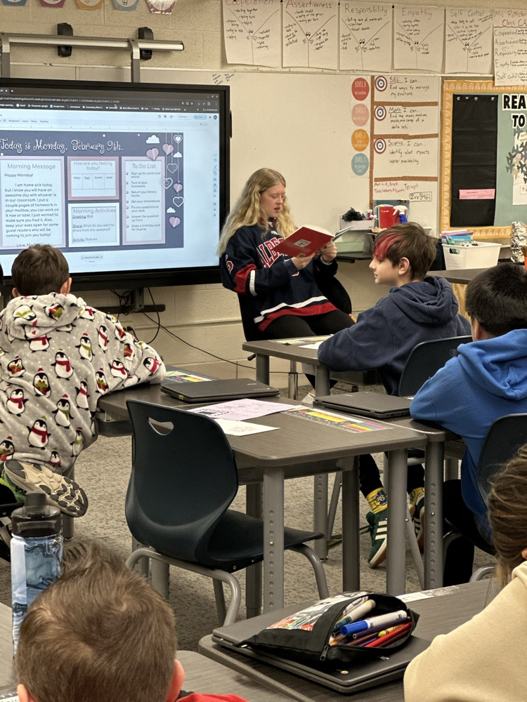 High school athletes reading to elementary students. 