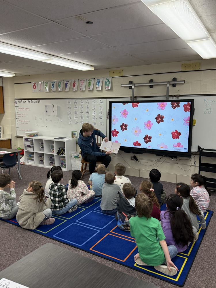 High school athletes reading to elementary students. 