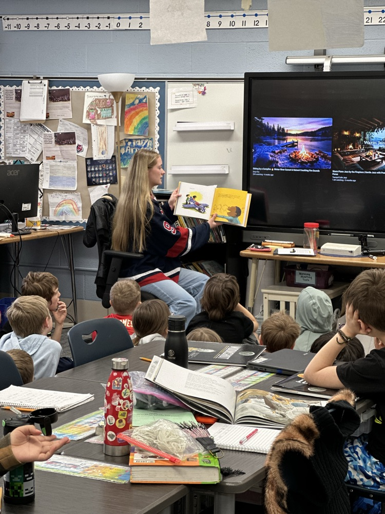 High school athletes reading to elementary students. 
