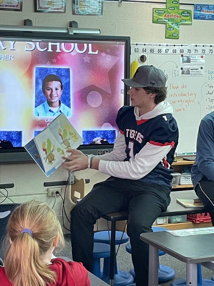 High school athletes reading to elementary students. 