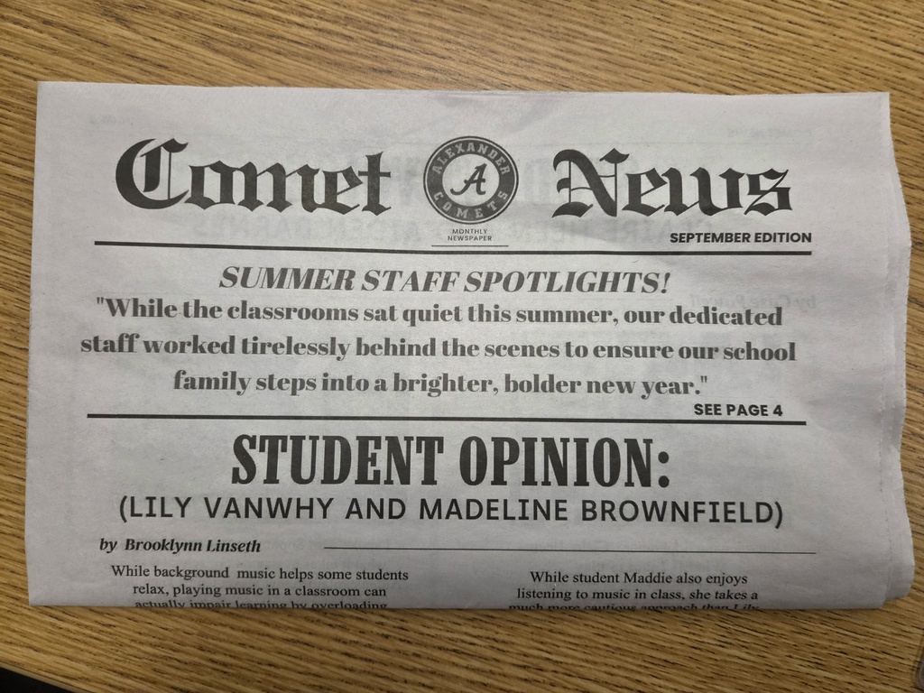 Front page of the September edition of the Comet News student newspaper from Alexander Public School, displayed on a wooden table. The headline highlights “Summer Staff Spotlights!” and recognizes school staff for their work preparing for the new school year. A featured article titled “Student Opinion” by Brooklynn Linseth discusses classroom music and includes student perspectives from Lily VanWhy and Madeline Brownfield. The Alexander Comets logo appears at the top center of the newspaper.