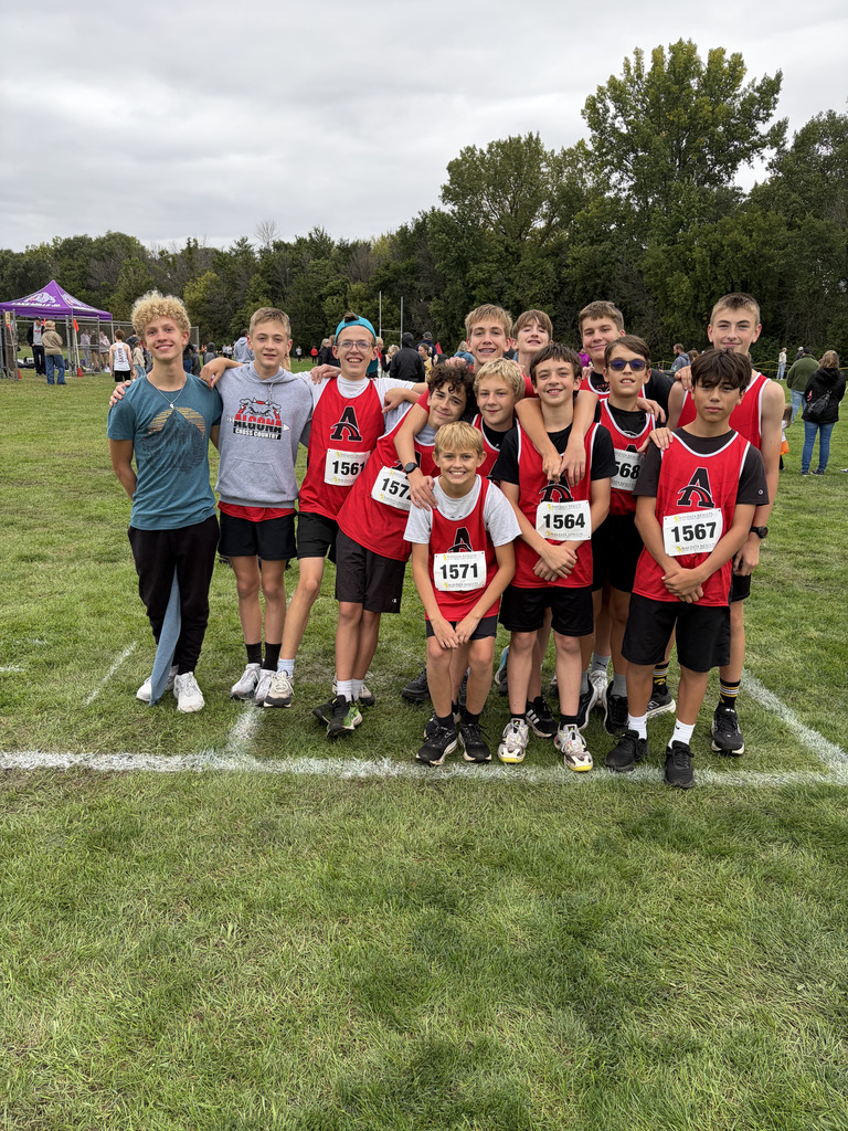 A group of young boys, likely athletes, stands on a field with numbers on their shirts.