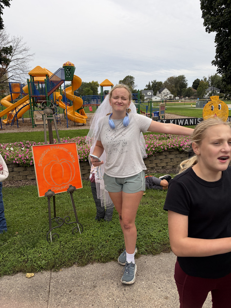 Two girls at a playground. One girl wears a veil and headphones, the other wears a black shirt.