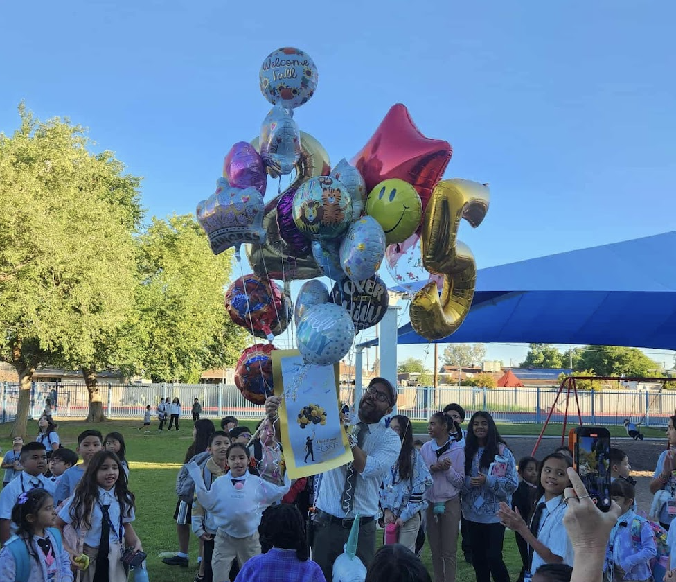 Dr. Landey with balloons and a poster.