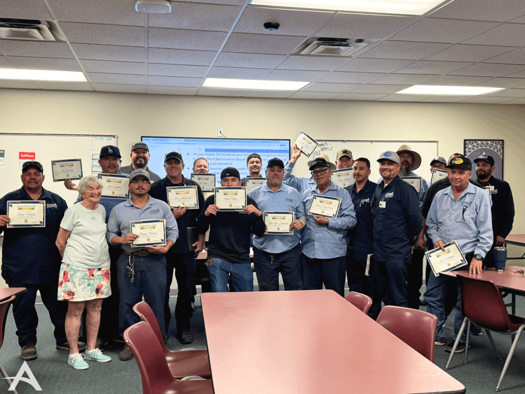 Group photo of multiple maintenance employees at Alhambra smiling and holding up certificates