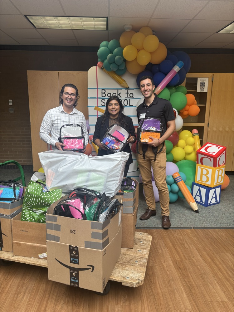 Mr. Tiago and Mr. Sosa-Sanchez donating backpacks and supplies to Martin Elementary