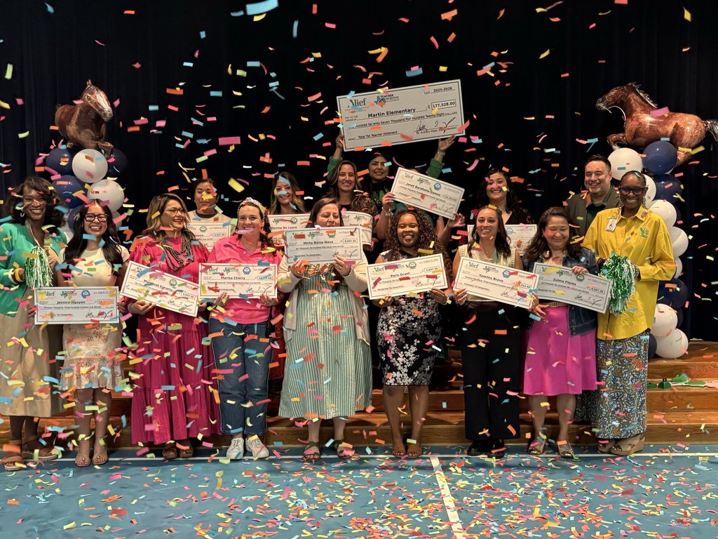People stand on a stage holding certificates and smiling, with confetti falling and balloons behind.