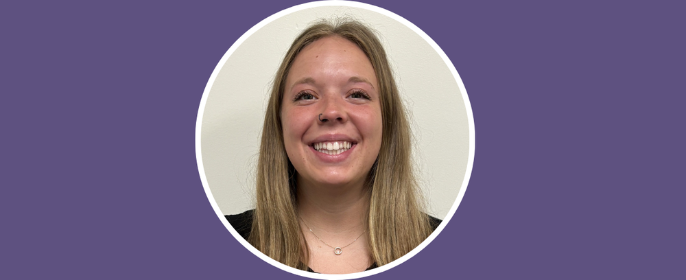 Lexie Bosch smiles at the camera with a purple background.