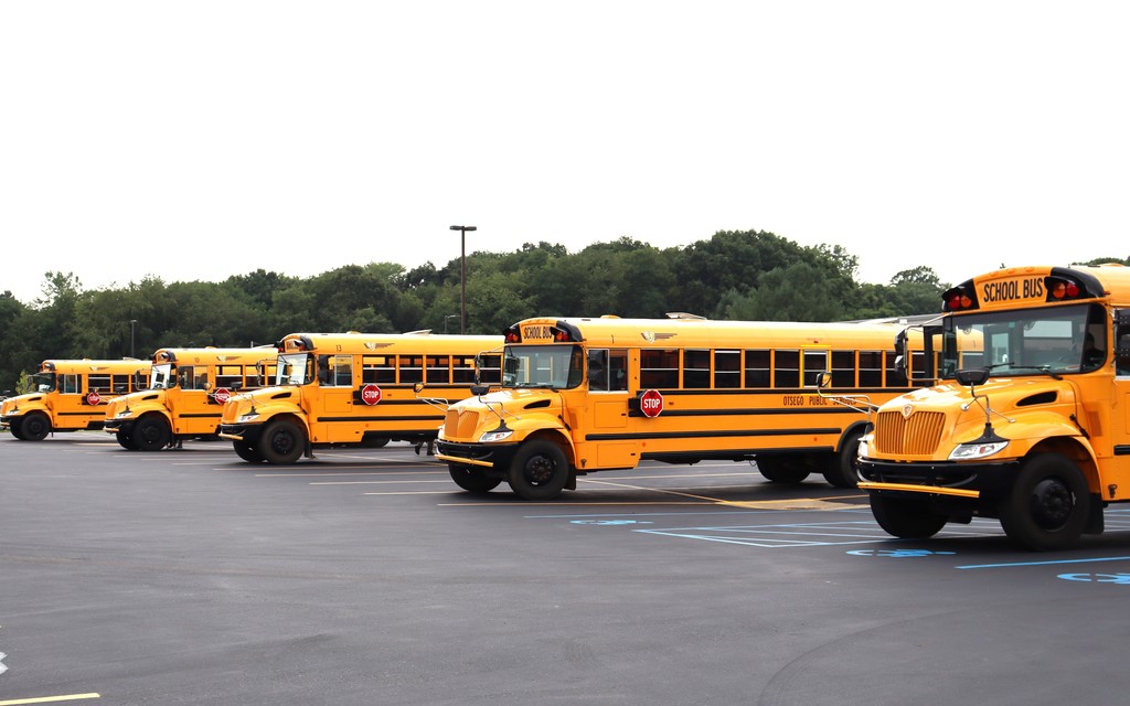 5 school buses parked in parking lot