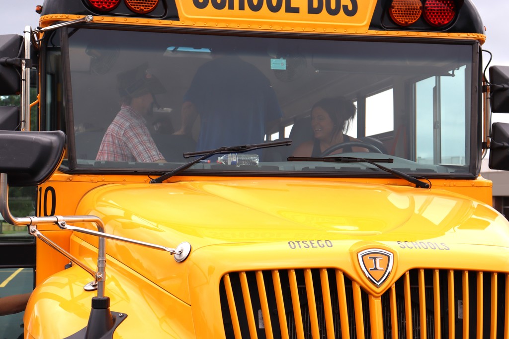 Bus driver smiles as passenger/trainee steps onto bus