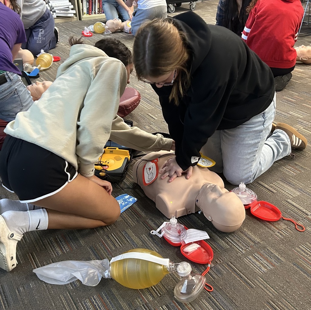 EMS students giving CPR mannequin compressions.