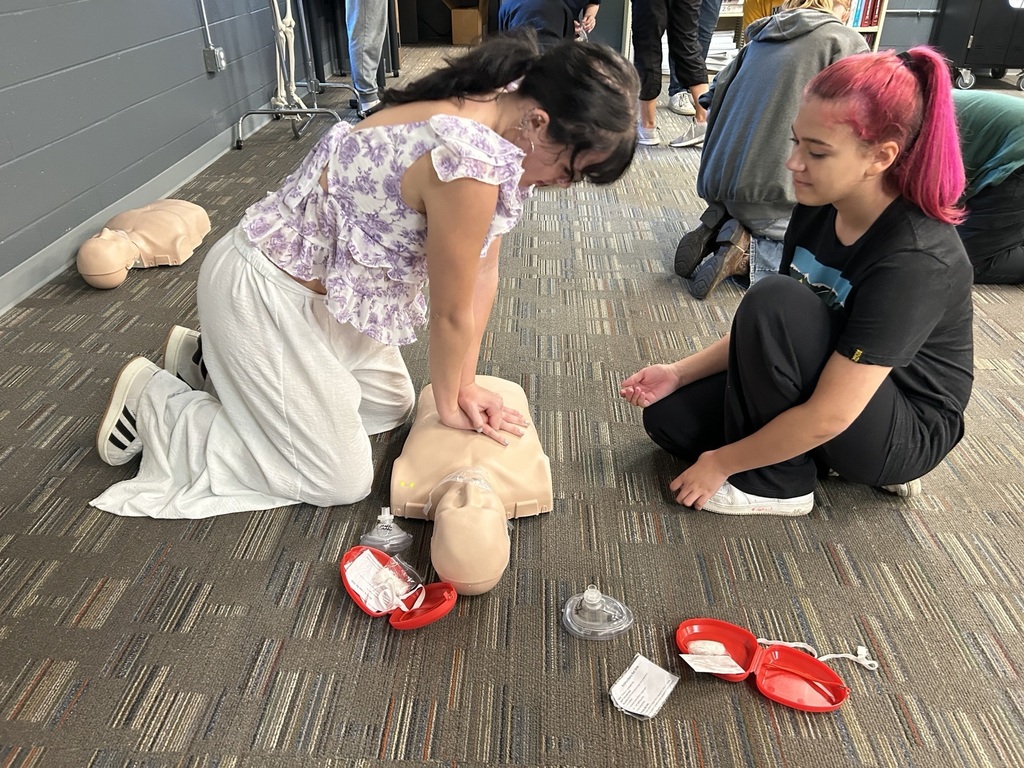 EMS students giving CPR mannequin compressions.