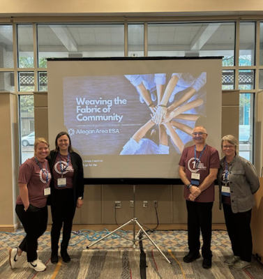Longcore, Tomlinson, Brown, and Reed post in front of presentation