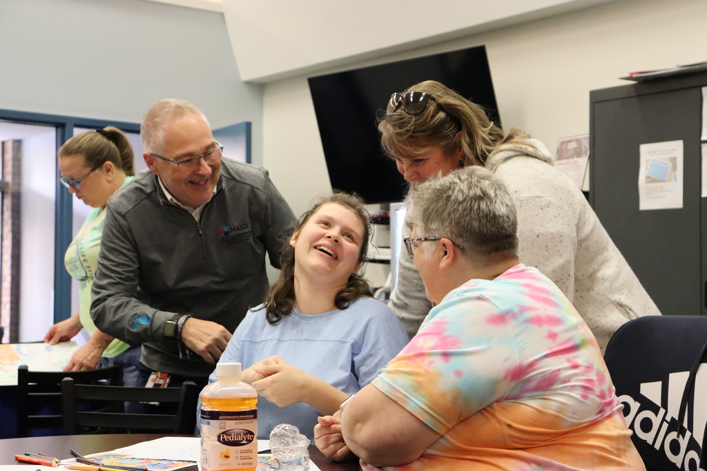 A student smiles with three staff