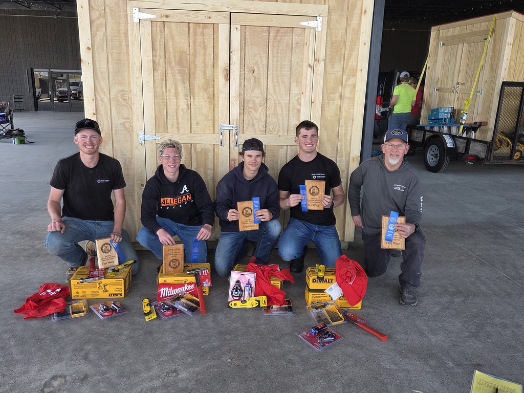 The four student team and instructor Andy Bishop holding their awards in front of their shed.