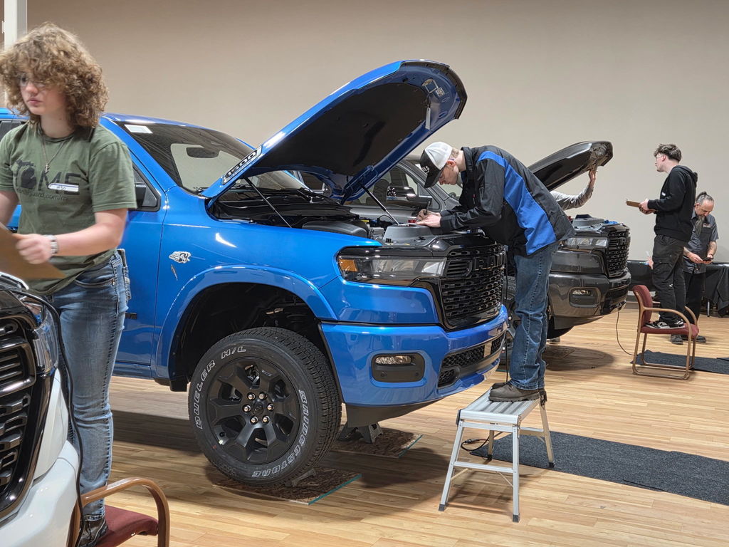 Daniel Doornhaag participating in one of the nine stations under the hood of a blue truck