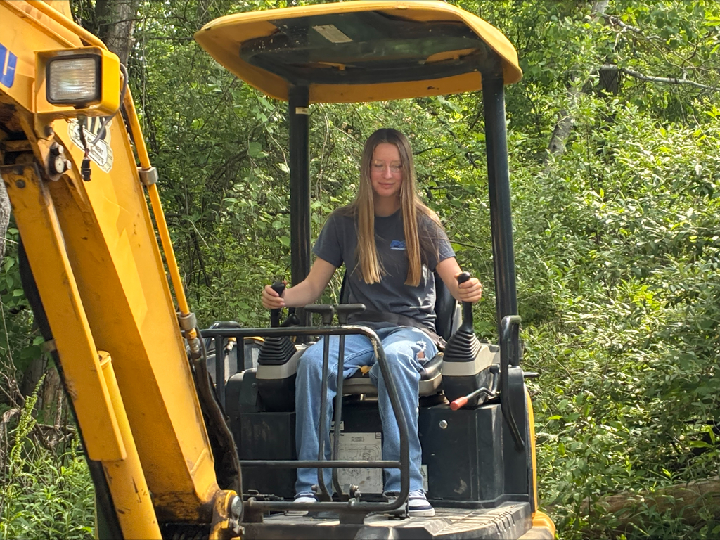 Camper on a yellow Komatsu excavator digging a hole.