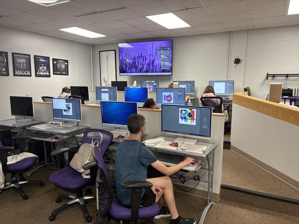 Students utilizing Adobe on the computers to design stickers