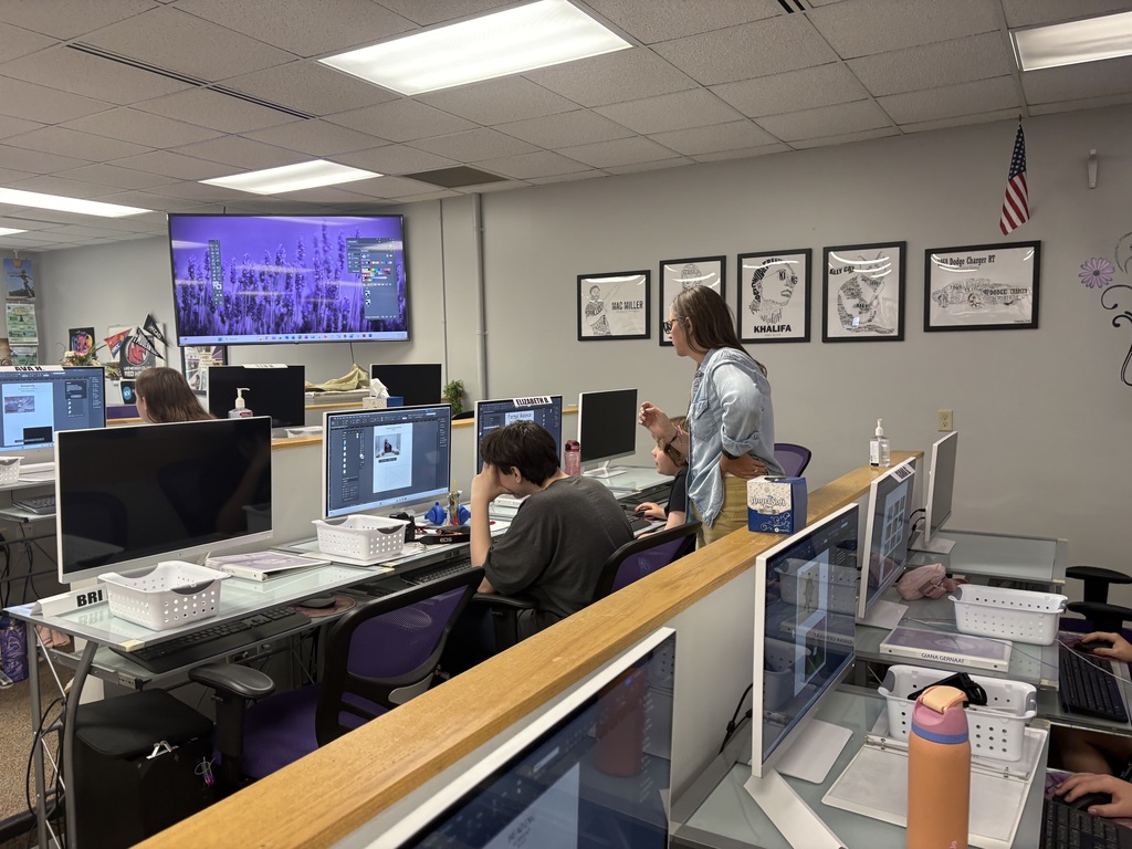 Photographer Instructor helping students with software on computer