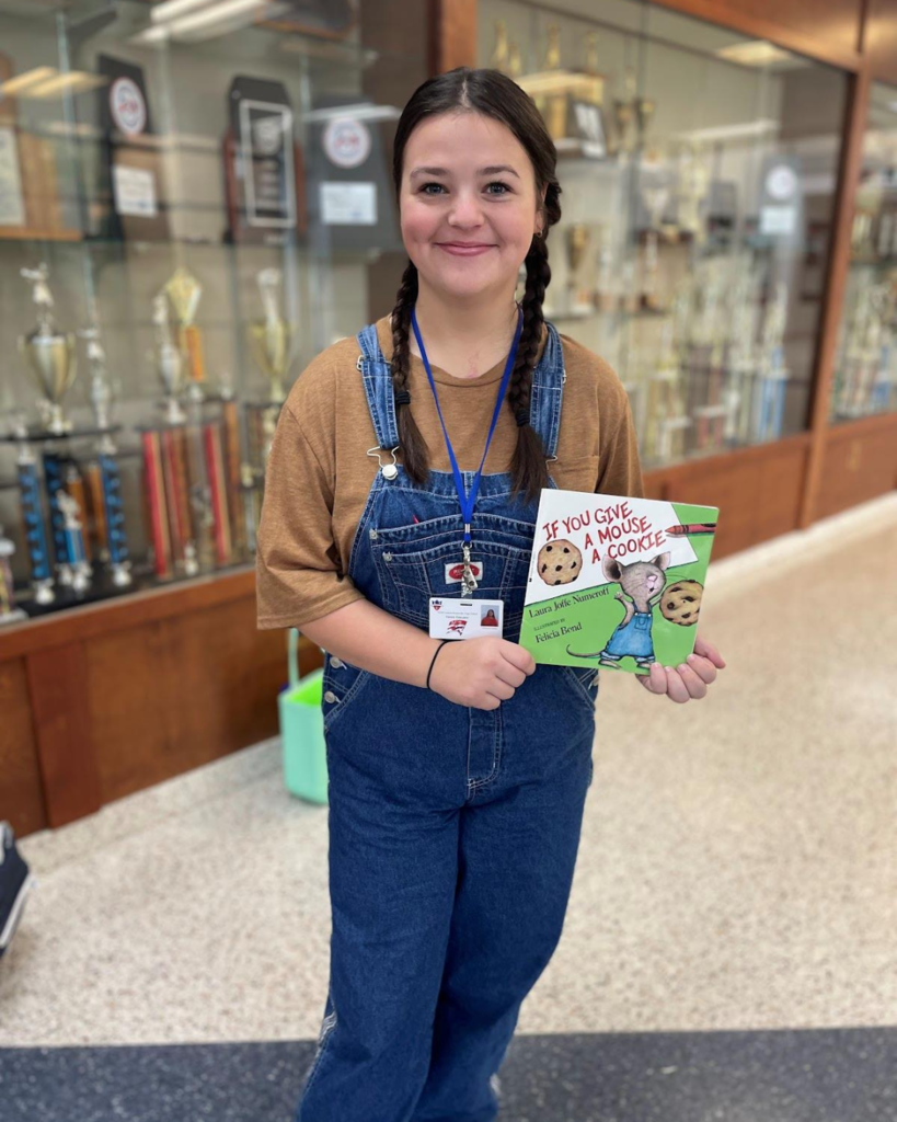 ACSHS student with book to teach lesson