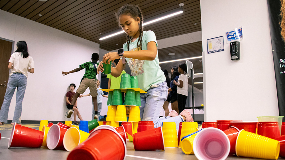 Girl stacks cups at Community Engagement Night