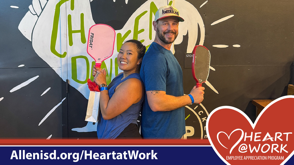 The mural has the word “CHICKEN” painted in green and white. One paddle says “FRIDAY.” The banner at the bottom reads “Allenisd.org/HeartatWork” and includes “HEART @ WORK Employee Appreciation Program” inside a red heart graphic.