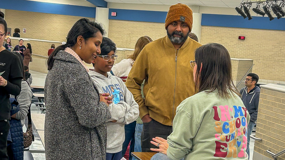 An incoming Curtis Middle School Family talks with a teacher at the Middle School Exp Night