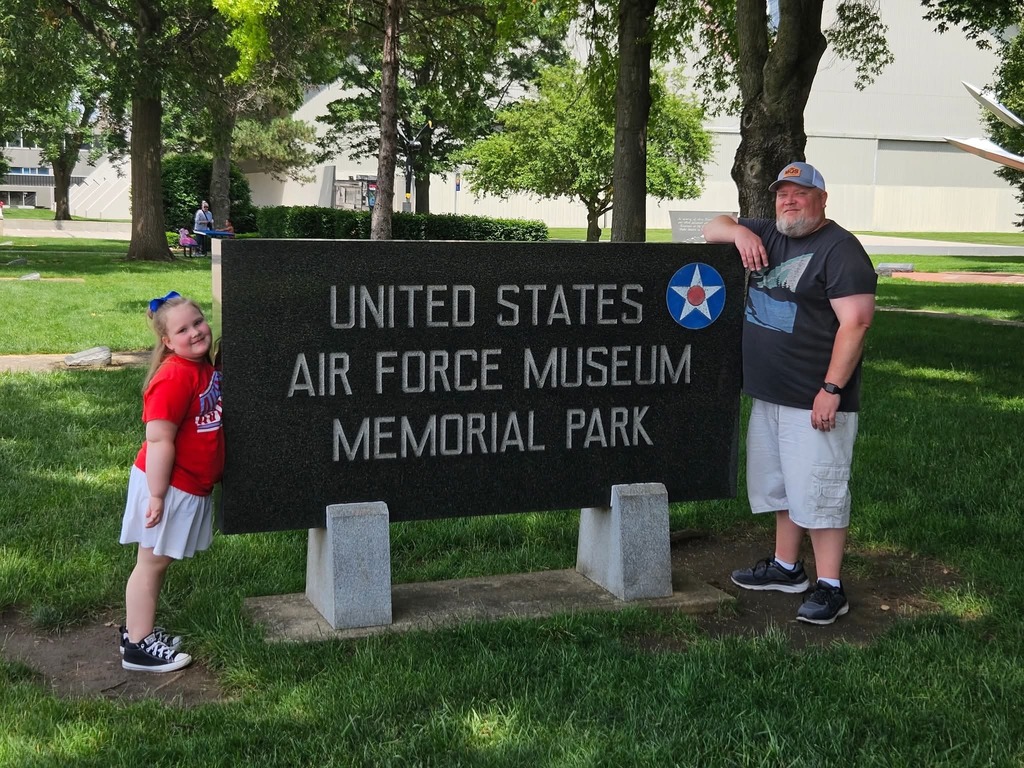 Rosaleigh in front of a sign that says Uniter States Air Force Museum Memorial Park