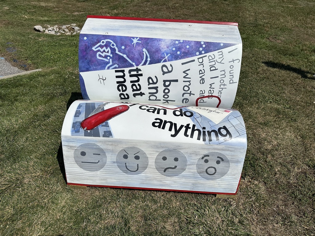 another bench painted with the saying "i found my mother and I was brave and I wrote a book and that means i can do anything" with emojis in the bench