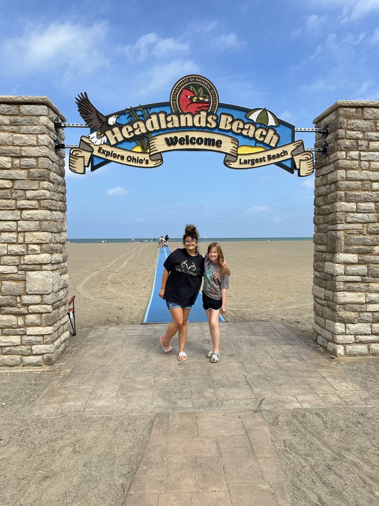 Aubree and Adelynn standing under the Headlands beach sign