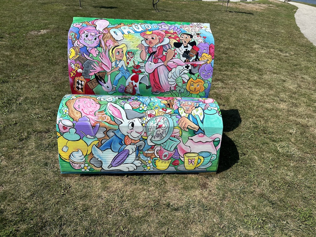 a storybook bench painted with Alice in wonderland characters