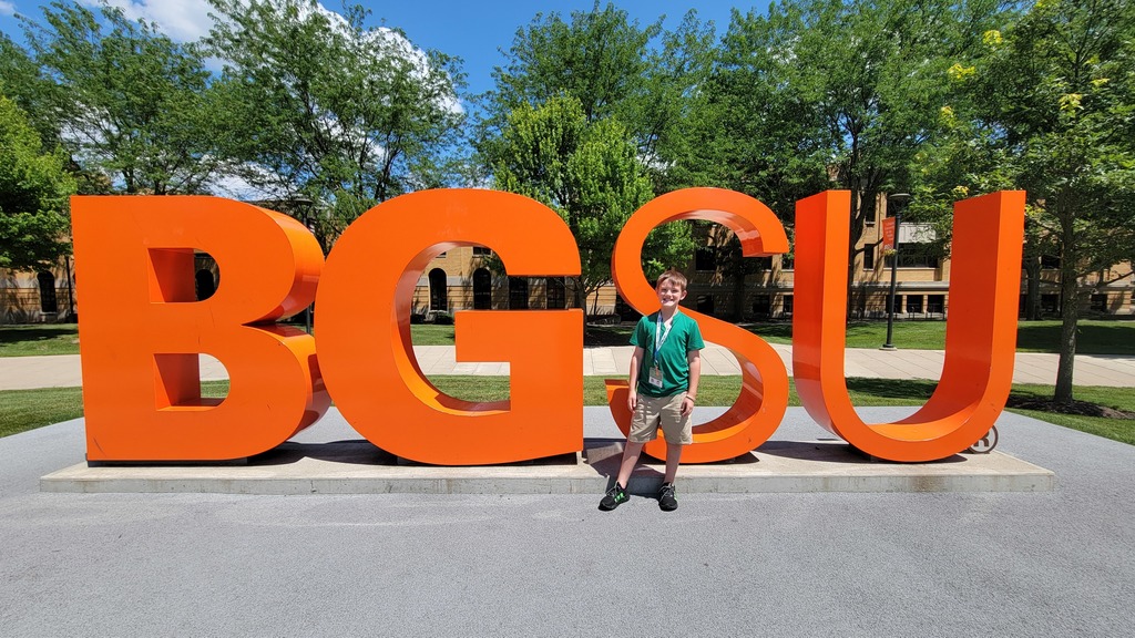 Lincoln standing in front of the BGSU sign