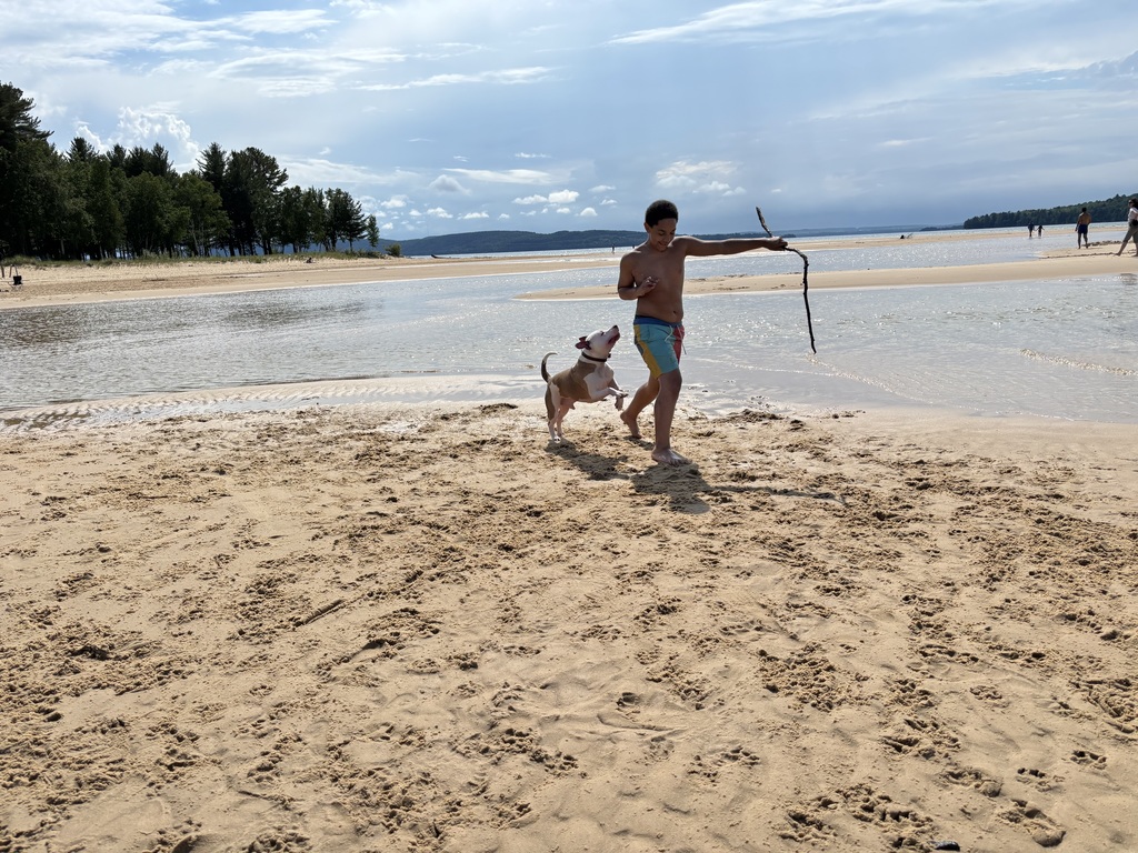 kevion playing with his dog on the beach